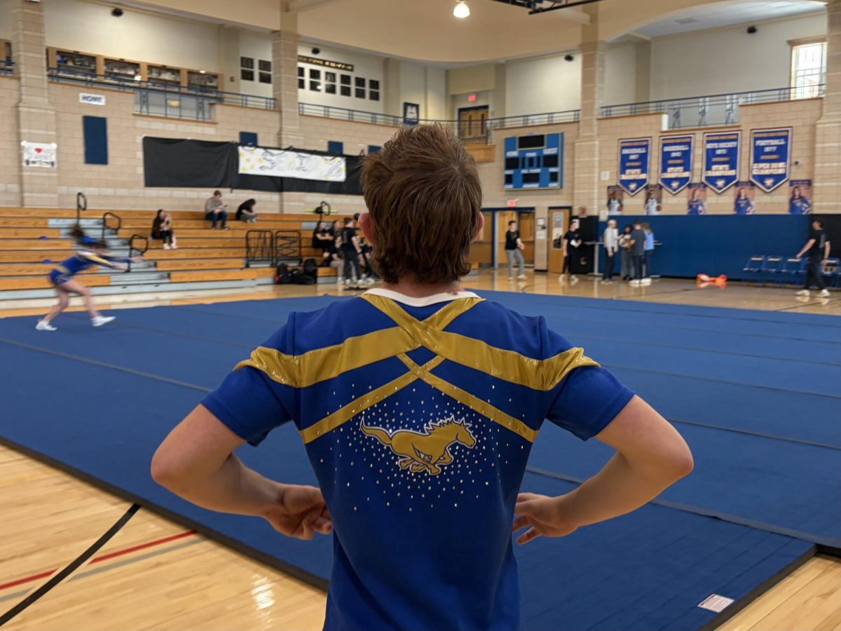Junior Aidan Feroli prepares himself to practice his cheer stunts.