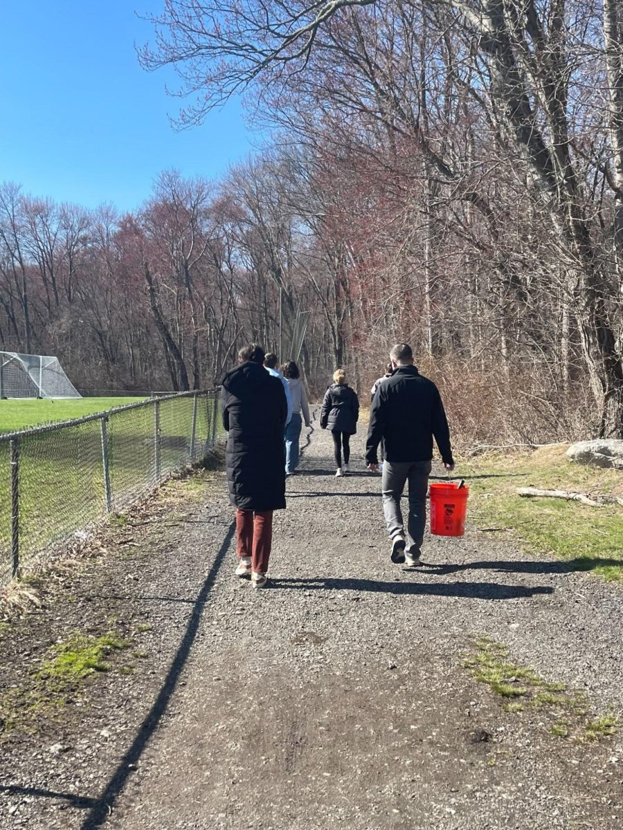 Volunteers walk together to prep the cement blocks a week before the Earth Week Block Painting Event