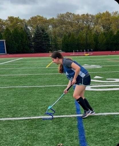 Alyssa Sutherland practicing Field    	     Sutherland with her crutches sitting
Hockey before her injury