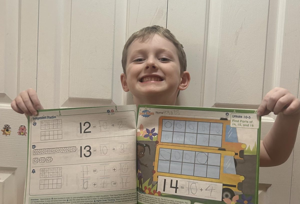 5-year old Norwood Kindergartener, James Hedderman shows off his math worksbook. 